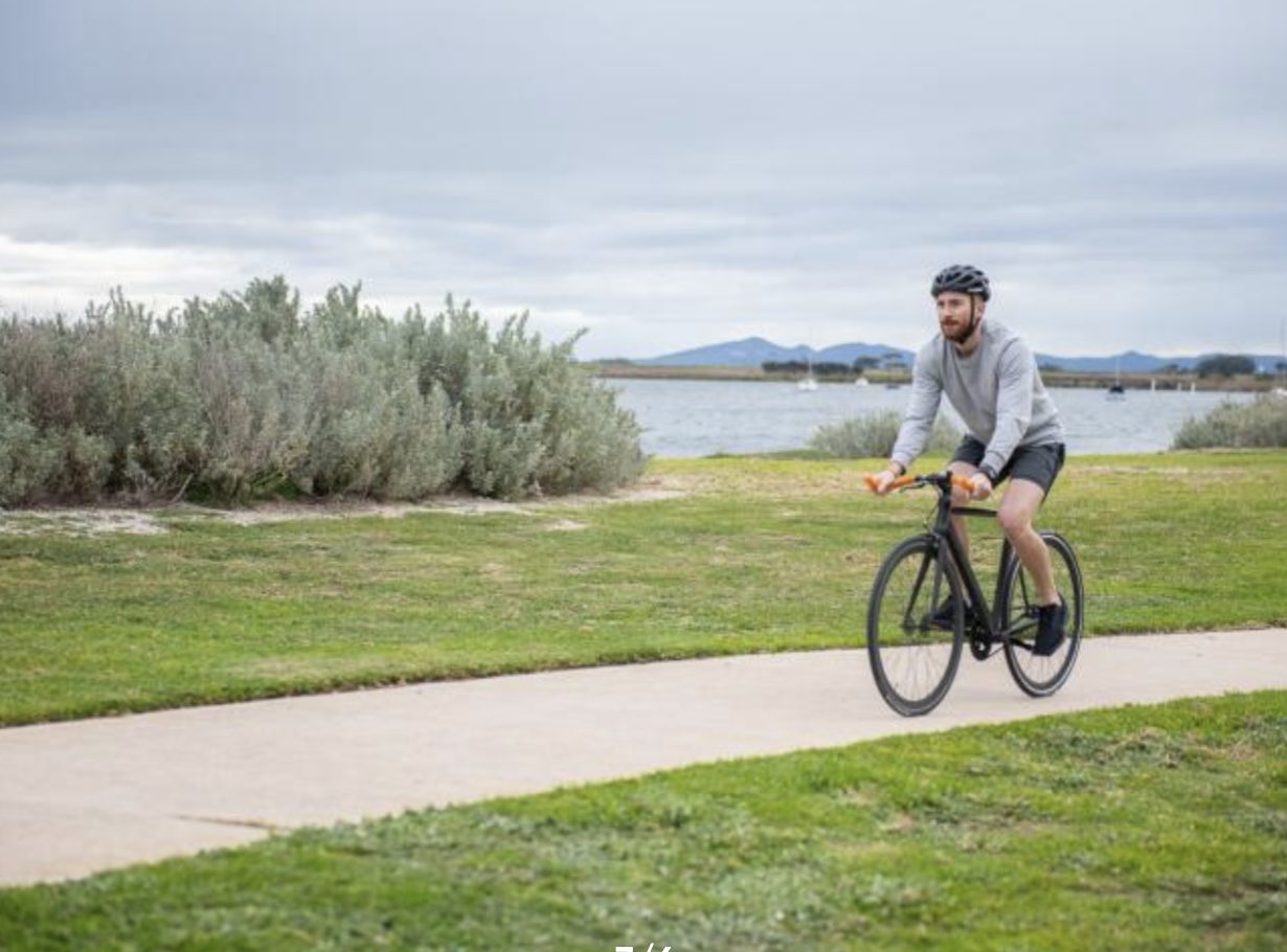 Cyclist riding a hire bike along the Port Phillip Bay trail