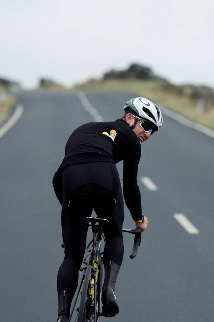 Road cyclist looking back on an open road